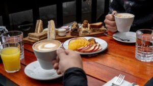 Enjoy a cozy coffee moment with assorted desserts on a wooden table.