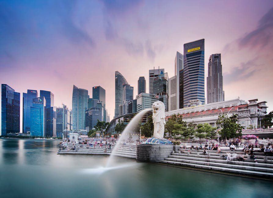 pexels-photo-15711737-15711737 Stunning view of Singapore's skyline featuring the famous Merlion fountain at dusk.